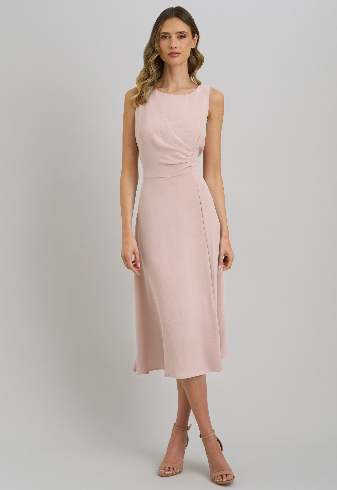 Woman wearing a pink dress against a gray background