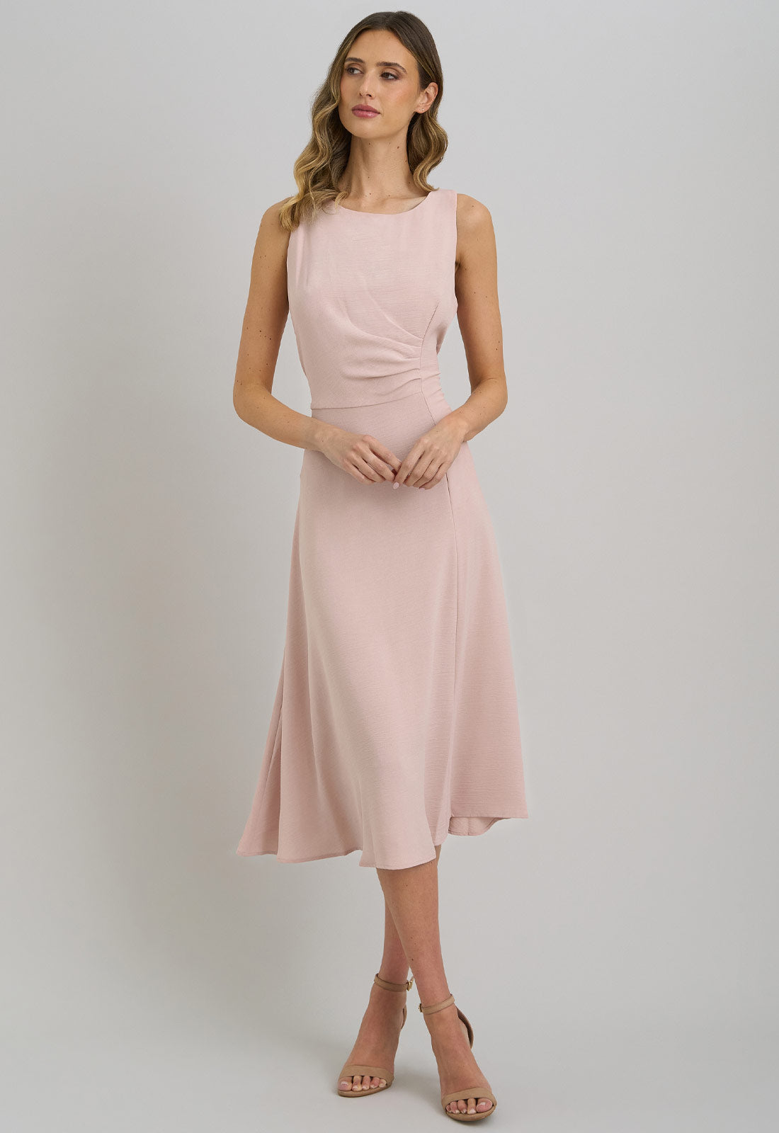 Woman wearing a pink dress on a plain background