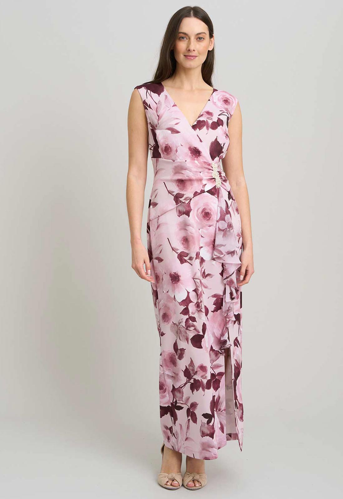 Woman wearing a pink floral dress on a light gray background