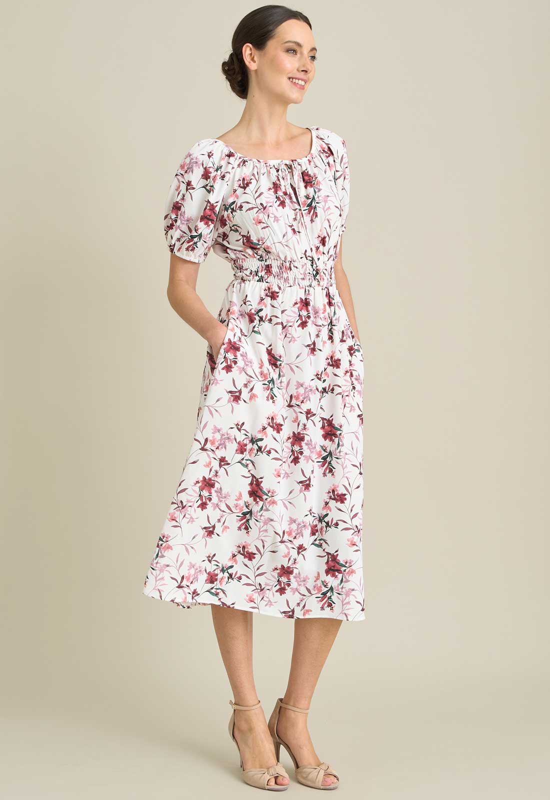 Woman wearing a floral dress on a beige background