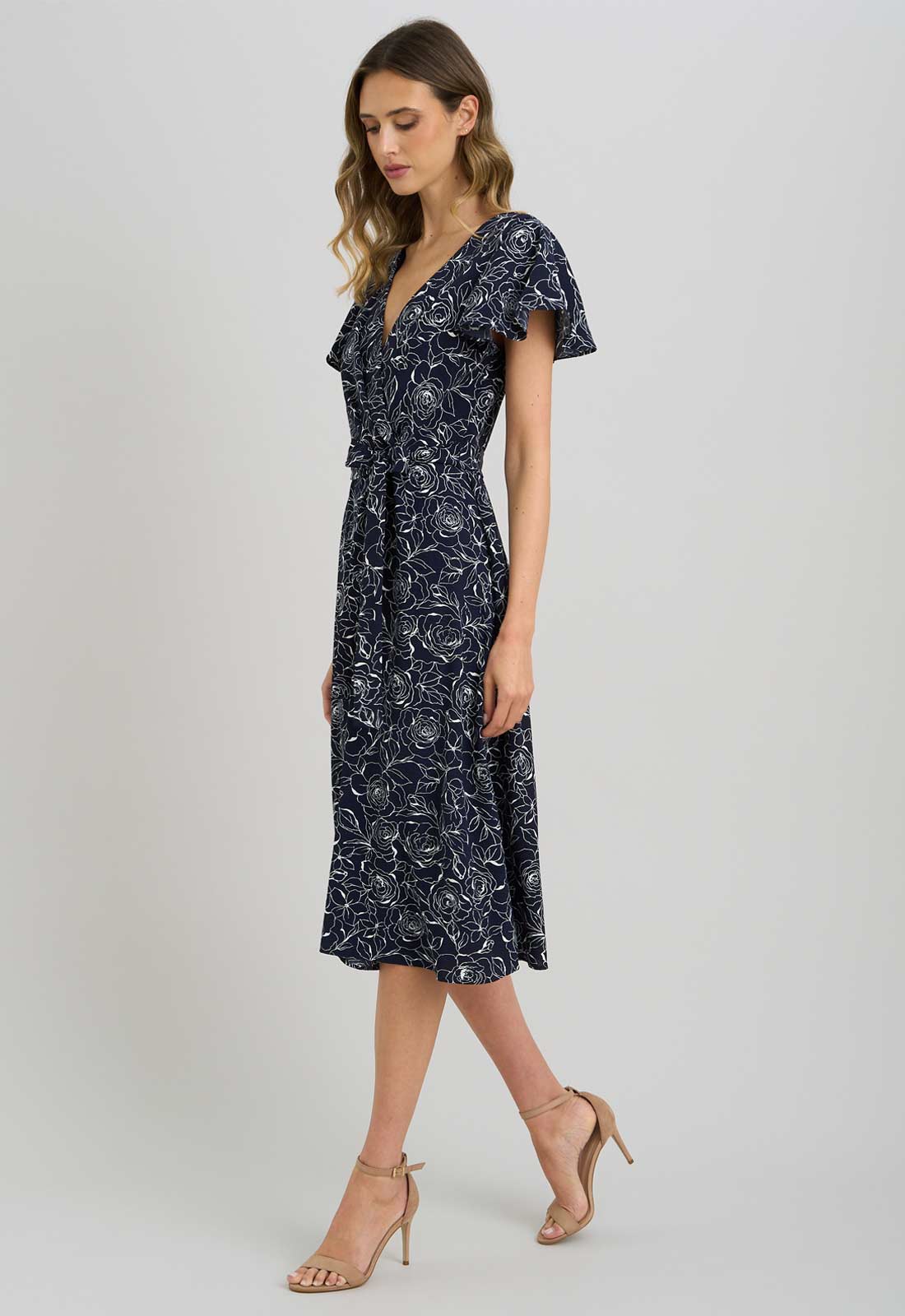 Woman wearing a navy floral dress on a white background
