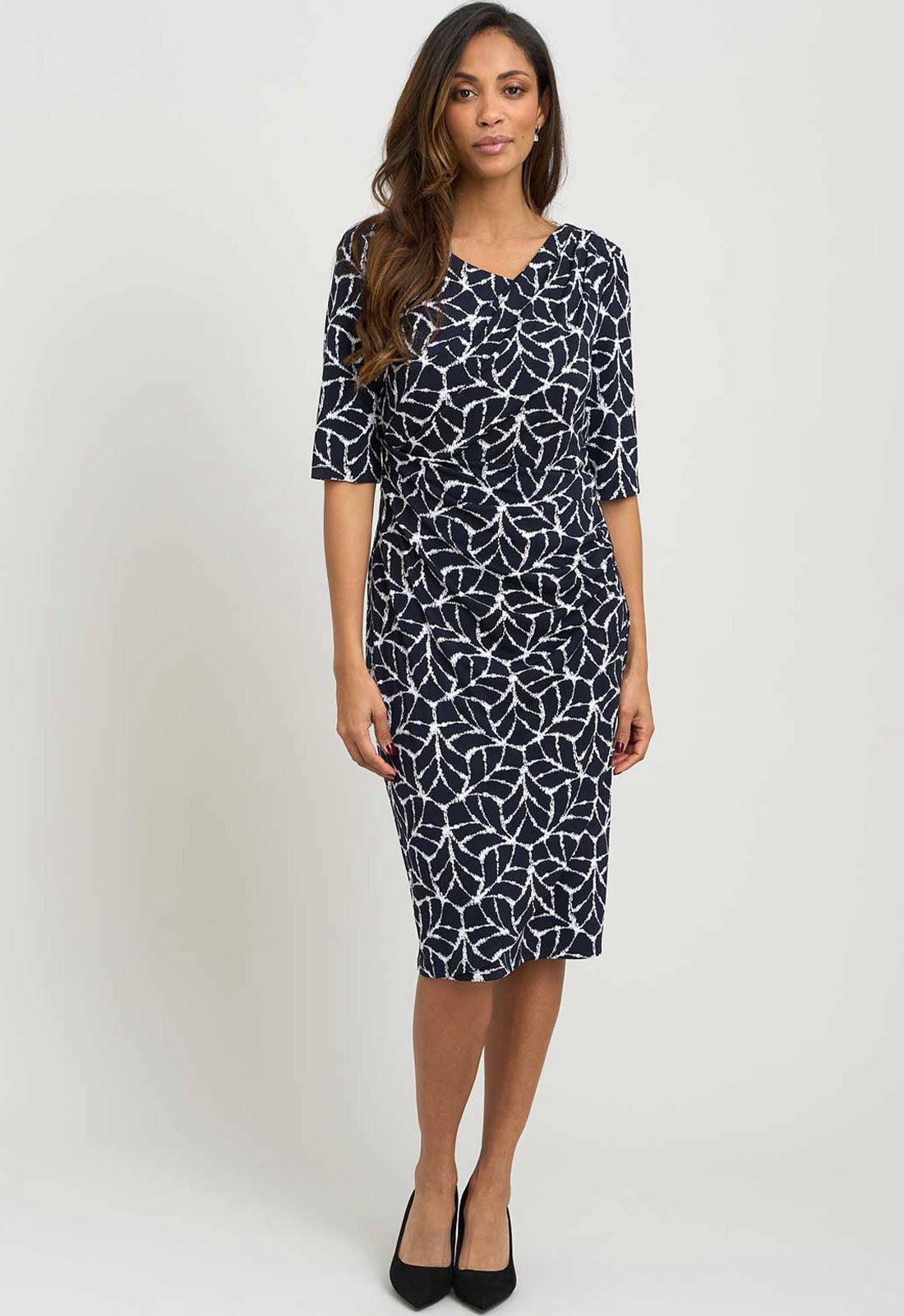 Woman wearing a navy patterned dress on a white background