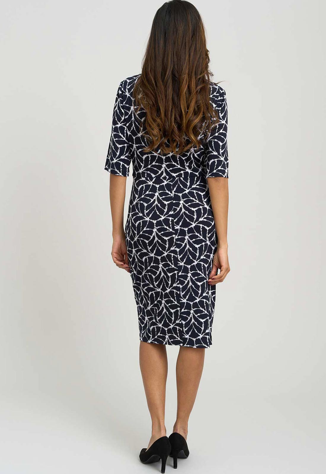Woman wearing a black and white patterned dress on a white background