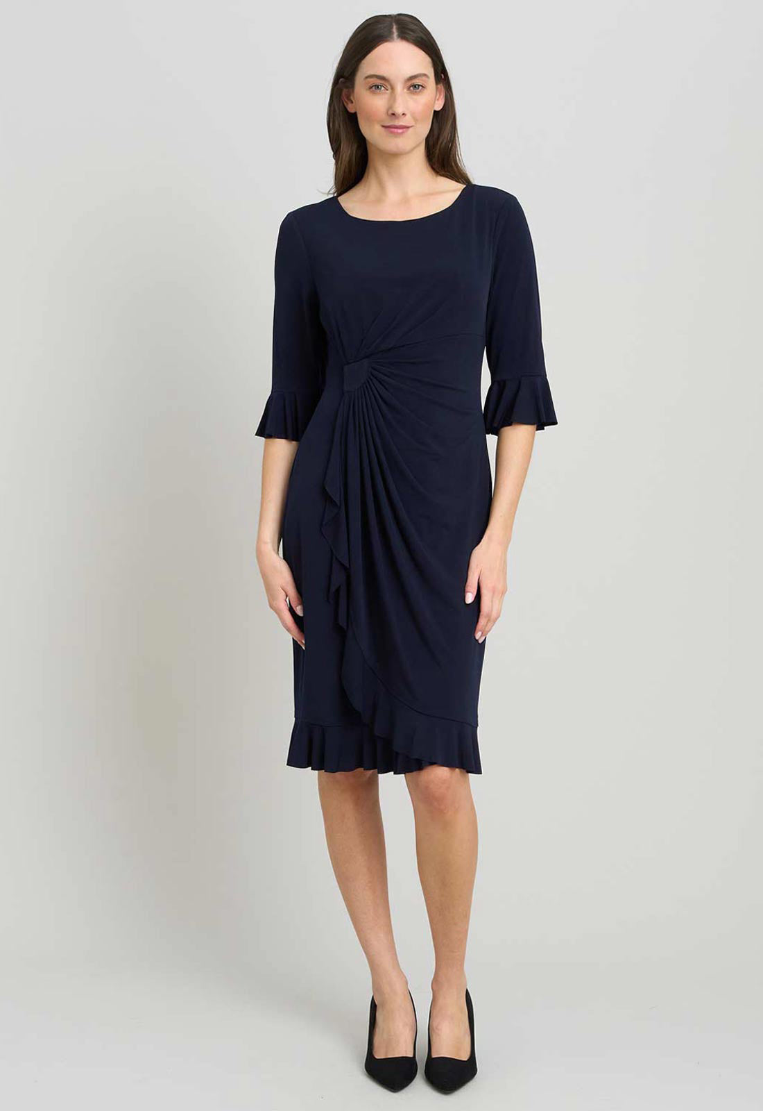 Woman wearing a navy blue dress with a plain background