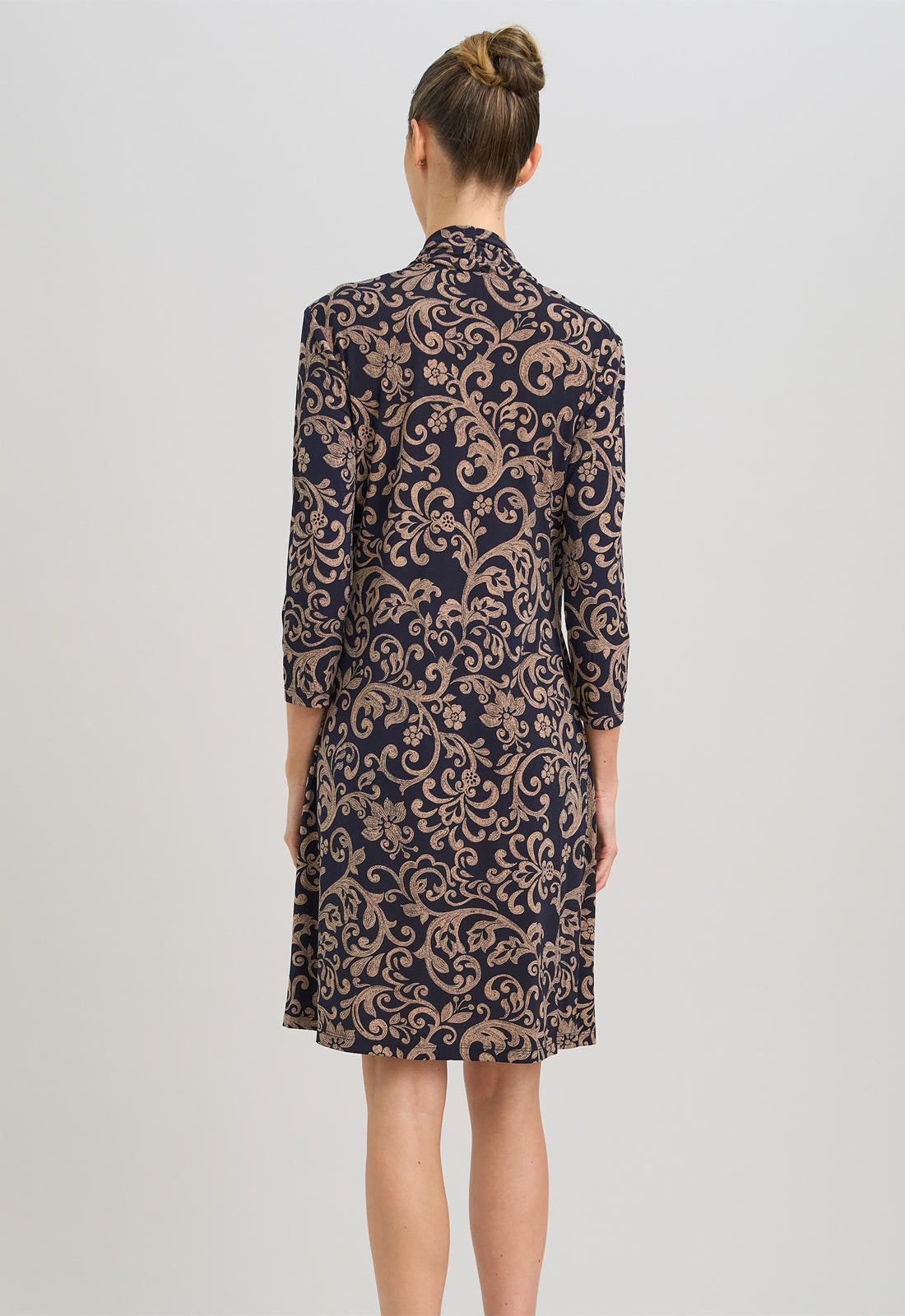 Woman wearing a patterned dress on a plain background