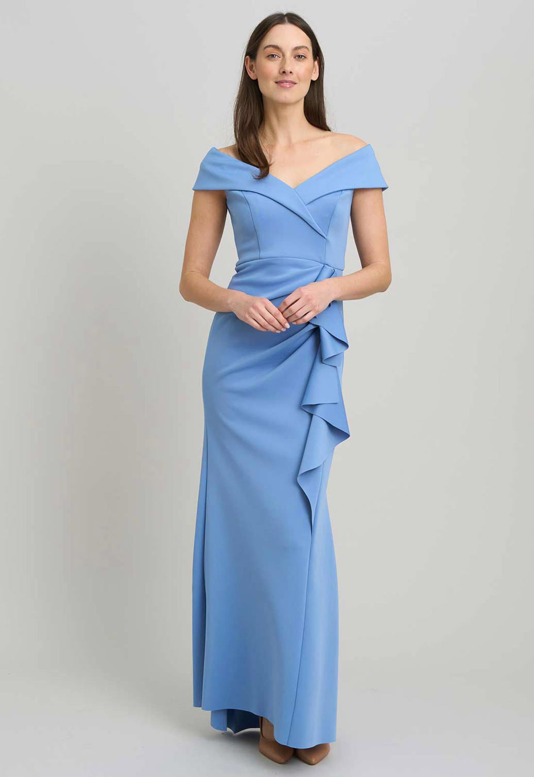 Woman wearing a blue off-shoulder gown on a light gray background