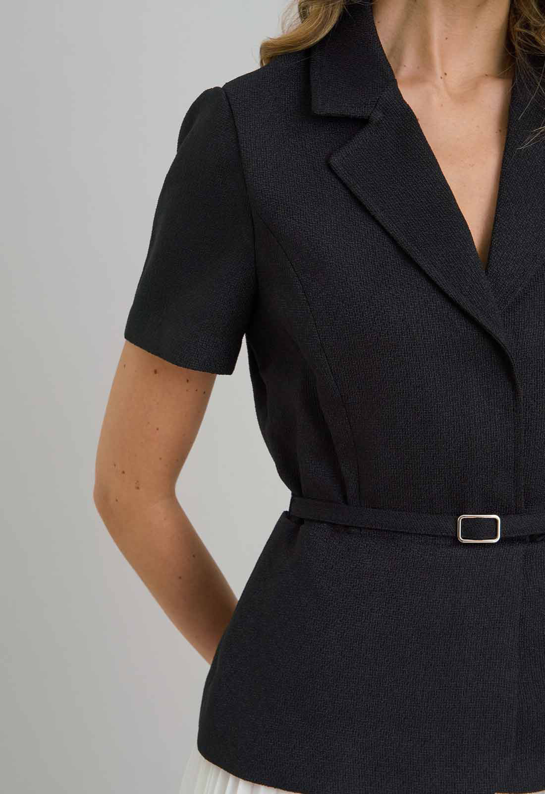 Black blazer with a belt on a plain background