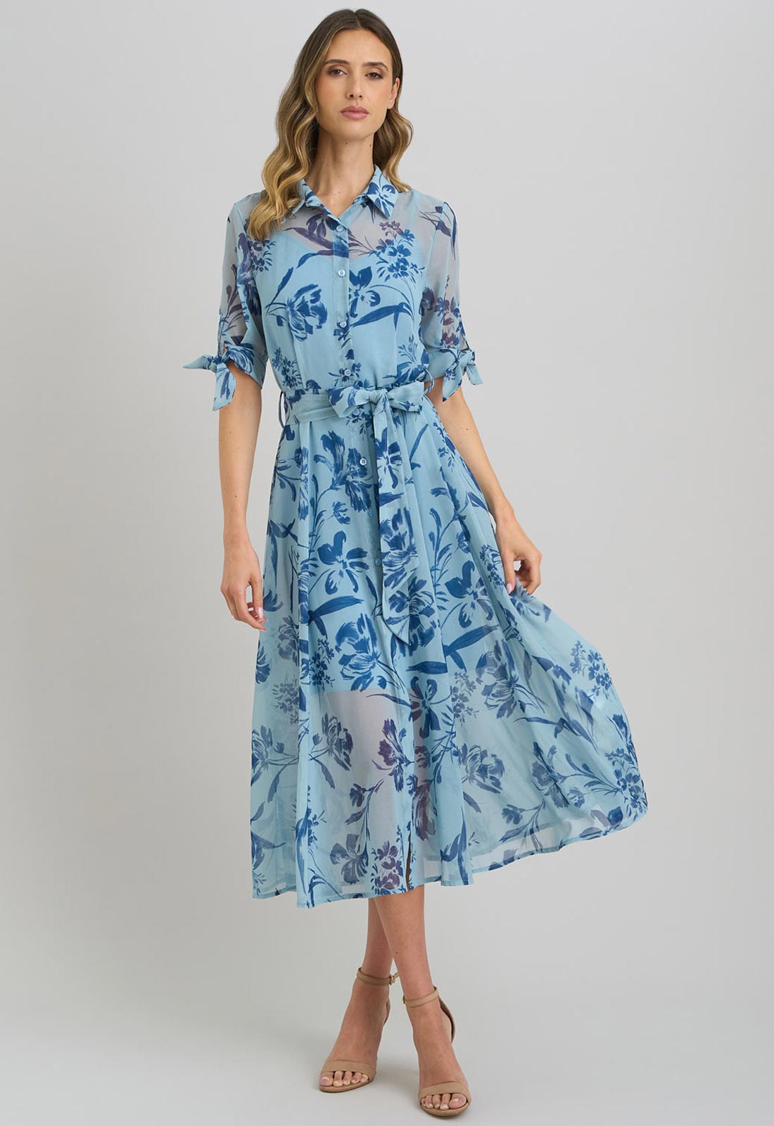 Woman wearing a blue floral dress on a gray background