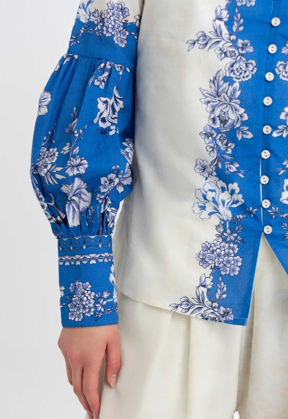 Blue floral patterned long-sleeve top on a white background