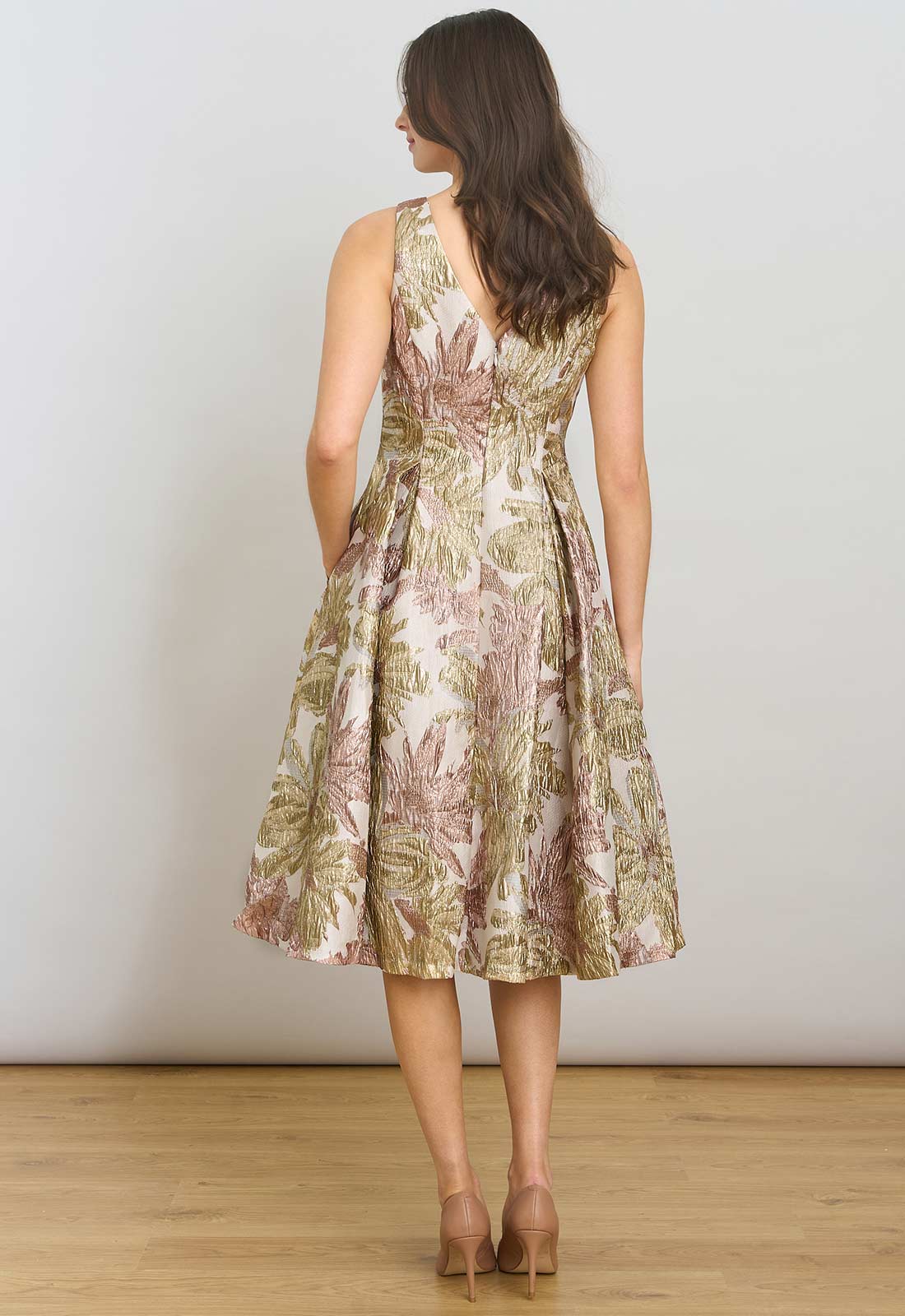 Woman wearing a floral dress against a plain background