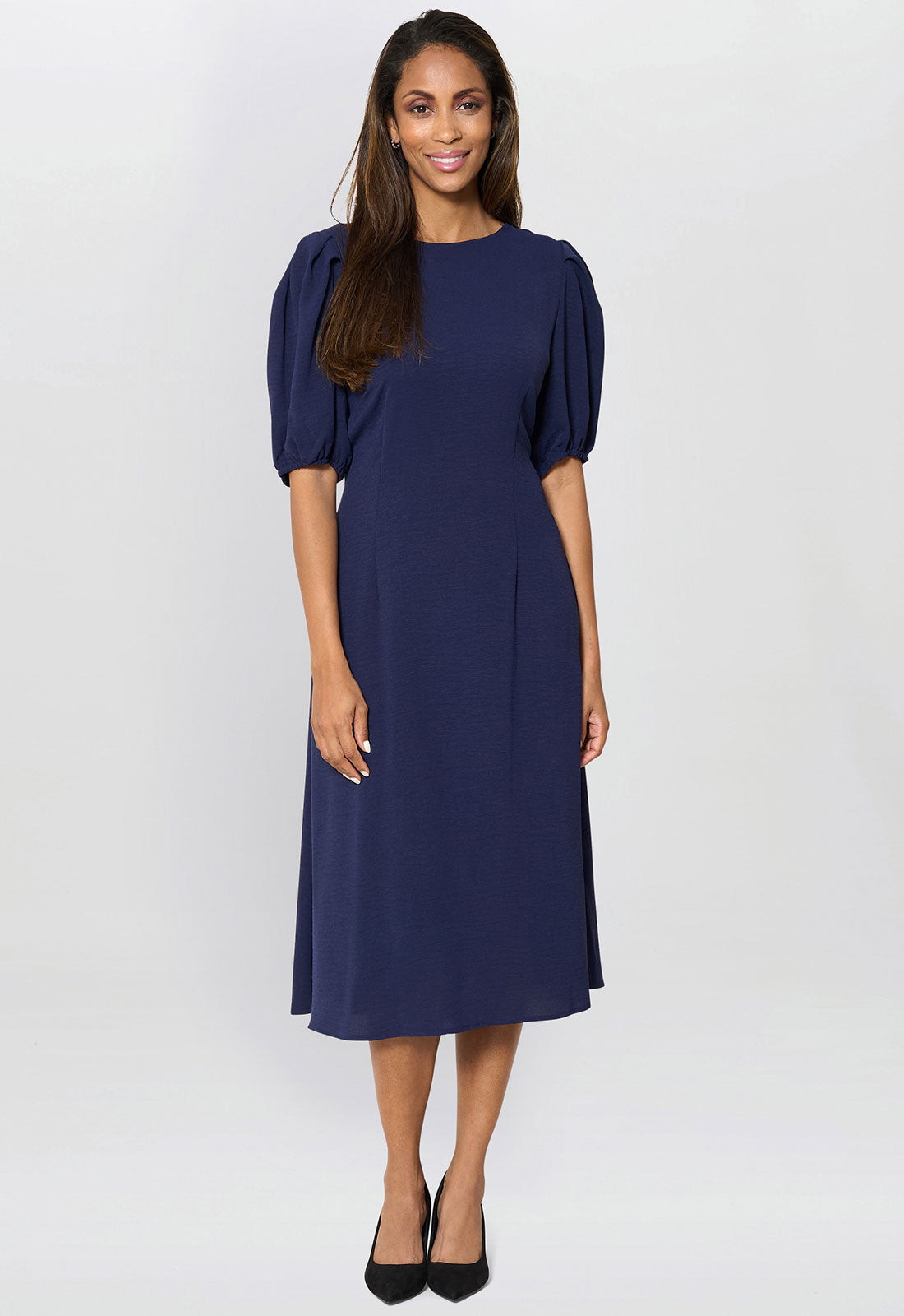 Woman wearing a navy blue dress on a white background