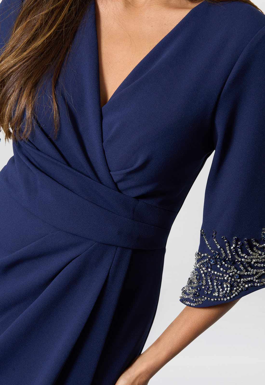 Navy blue dress with beaded sleeves on a white background