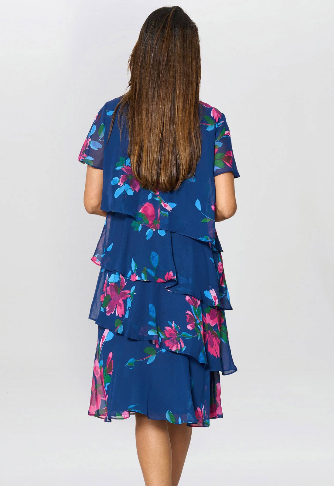 Woman wearing a blue floral dress with a plain background