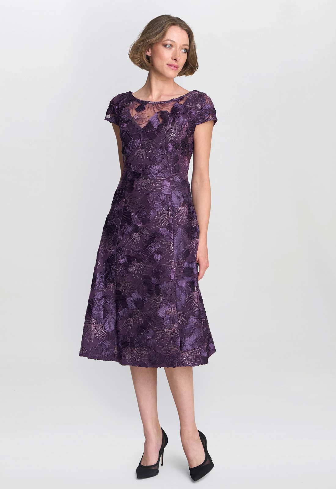Woman wearing a purple lace dress on a white background