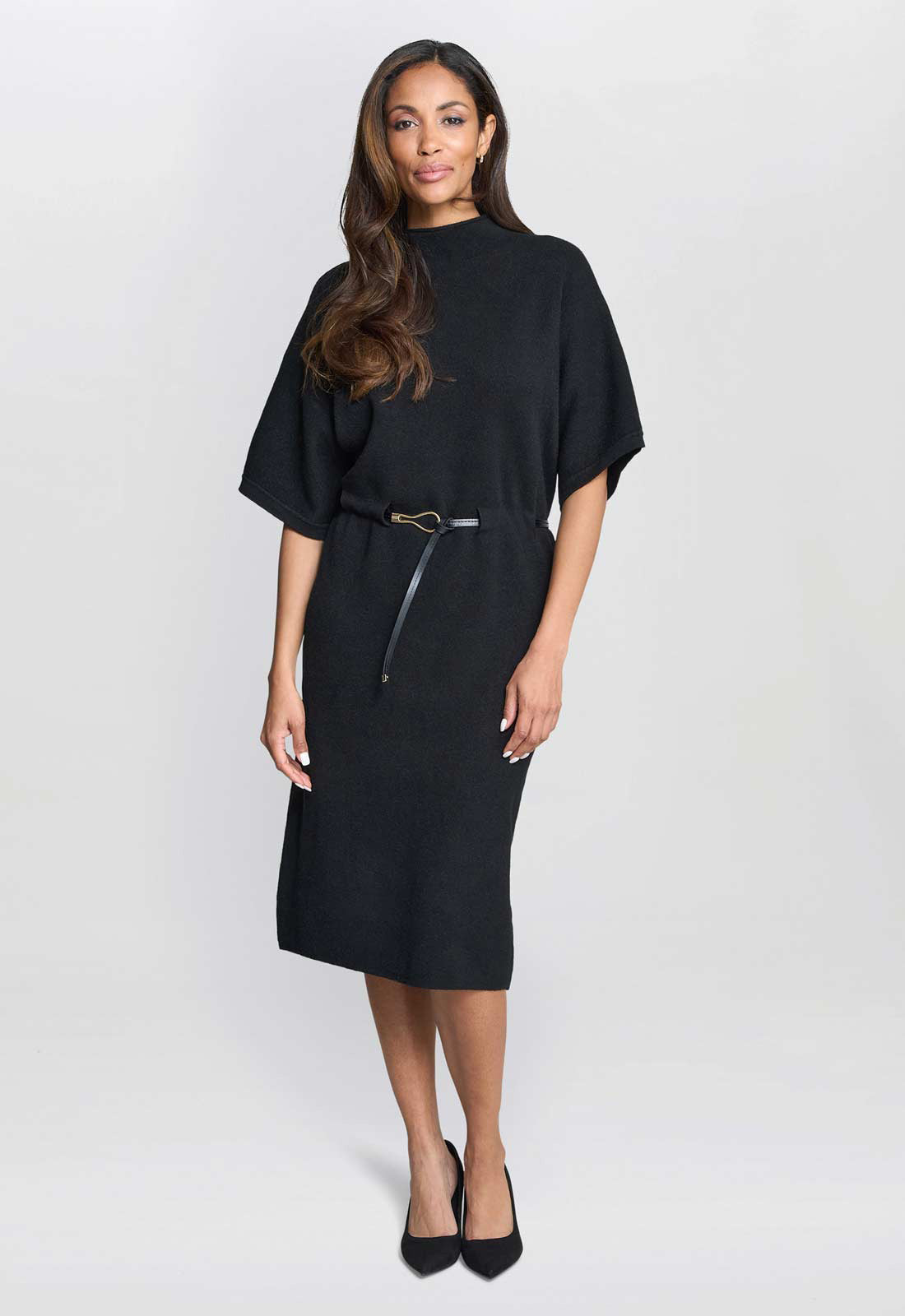 Woman wearing a black dress with a belt on a white background