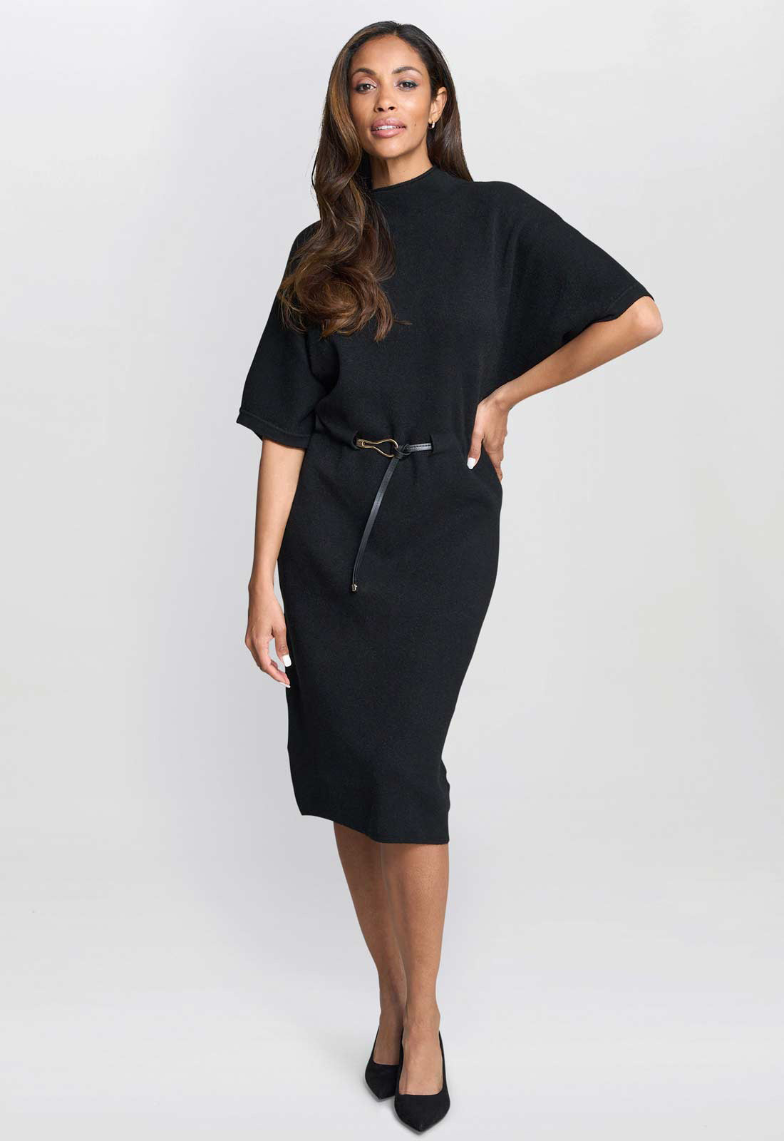 Woman wearing a black dress with a belt on a white background