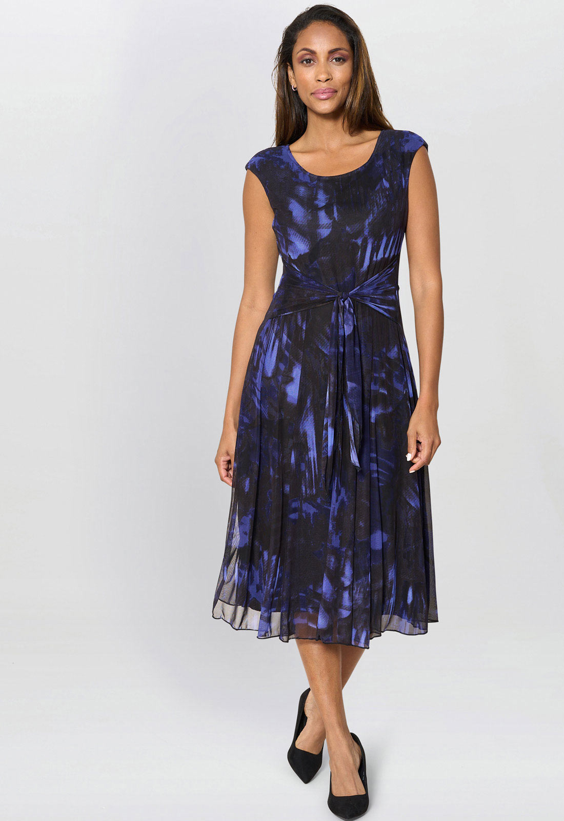 Woman wearing a blue and black patterned dress on a white background