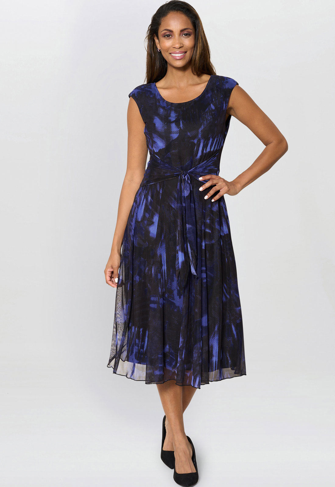 Woman wearing a blue and black patterned dress on a white background