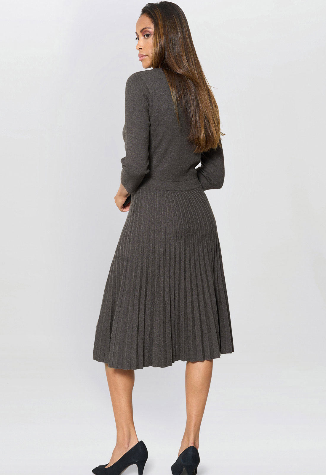 Woman wearing a gray pleated dress on a white background