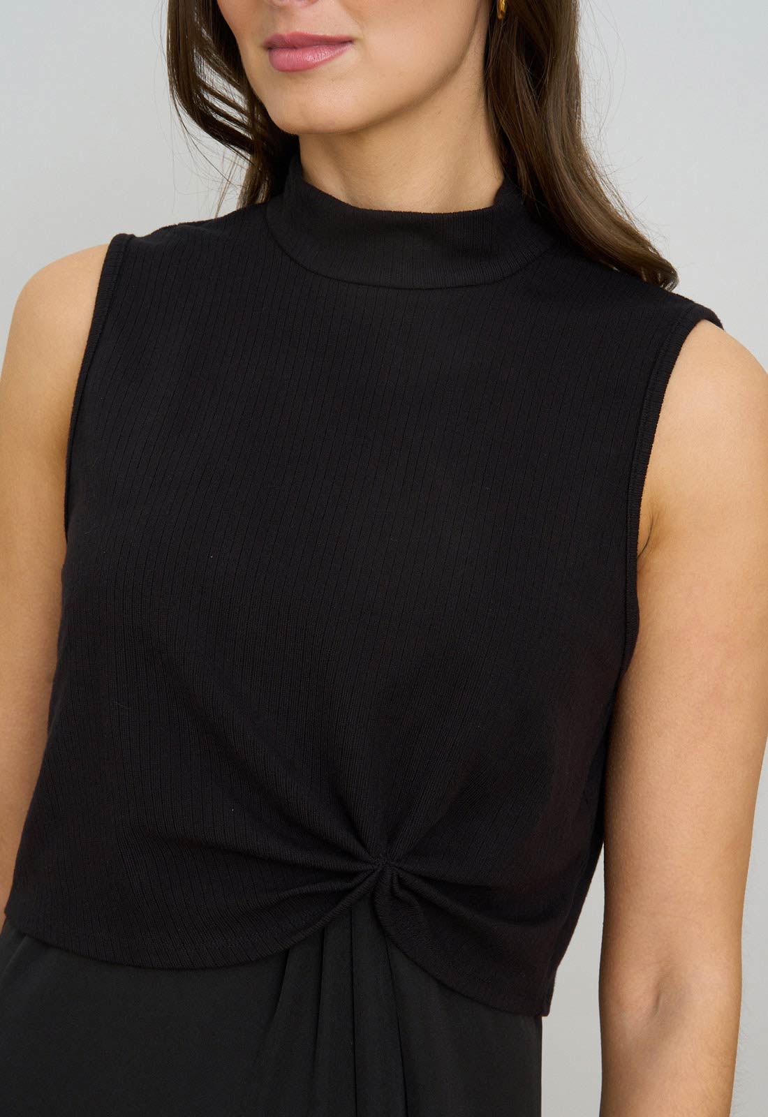 Black sleeveless top with a knot detail on a plain background