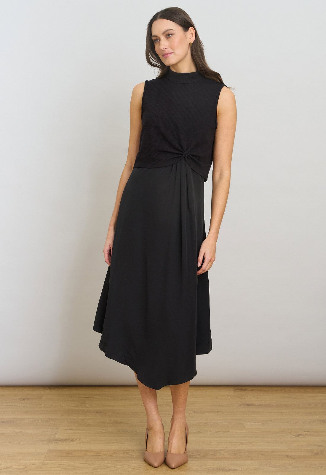 Woman wearing a black sleeveless dress against a white background