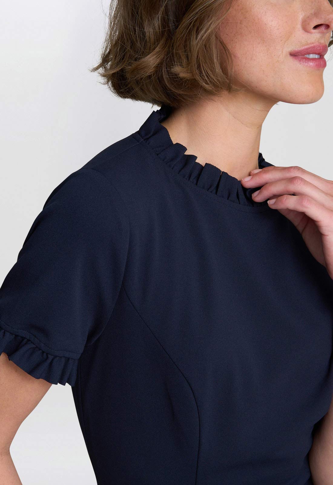 Navy blue dress with ruffled neckline on a white background