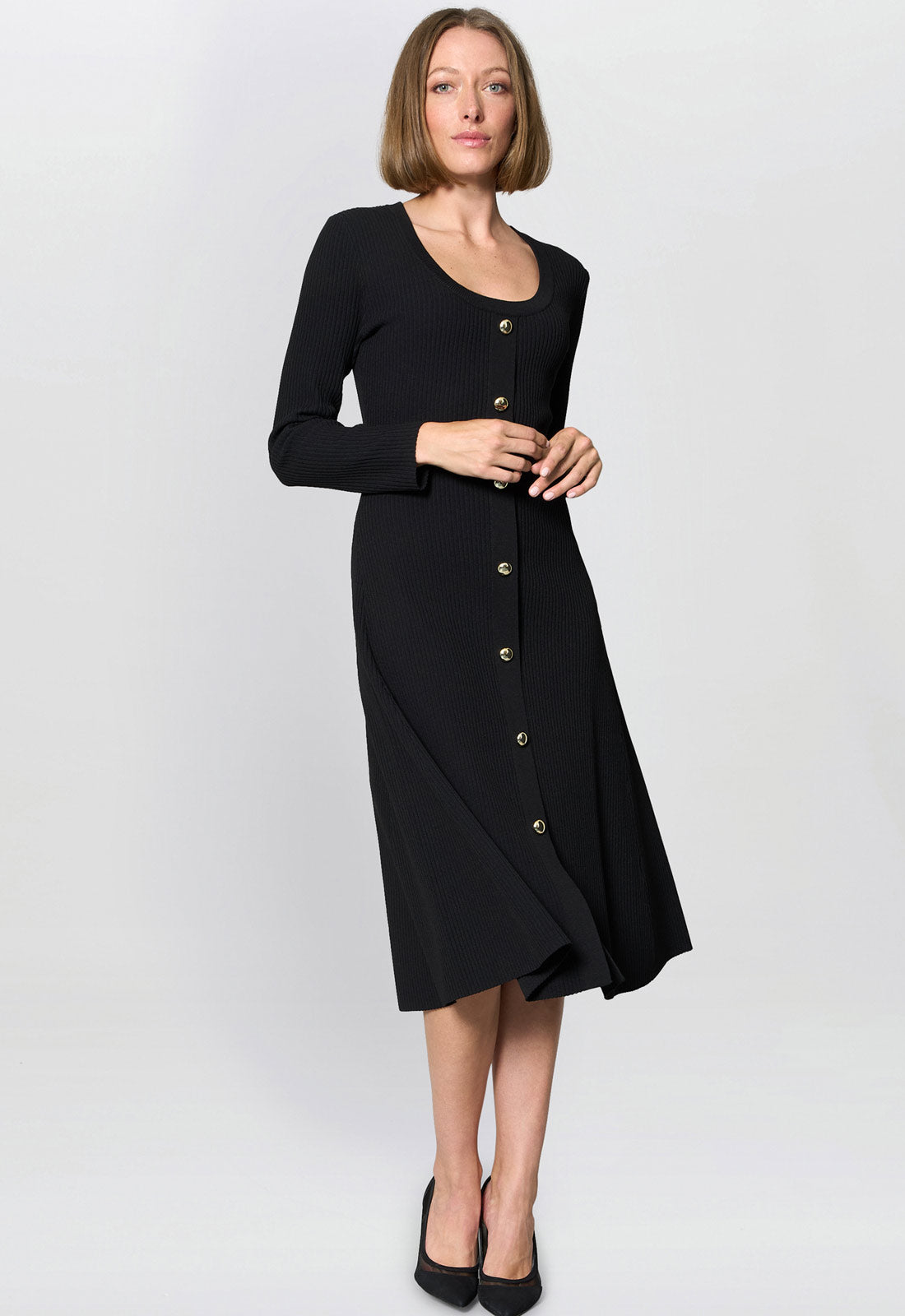 Woman wearing a black dress with buttons on a white background