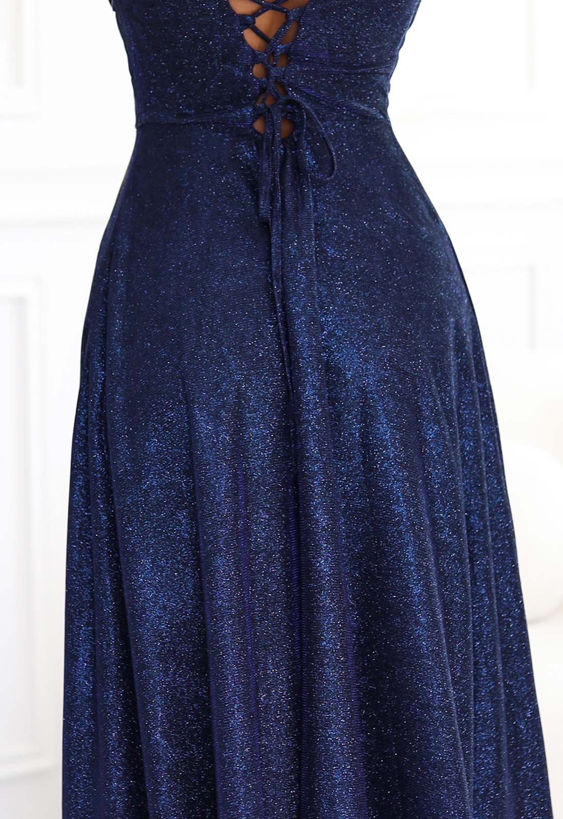 Navy blue dress with lace-up front on a white background
