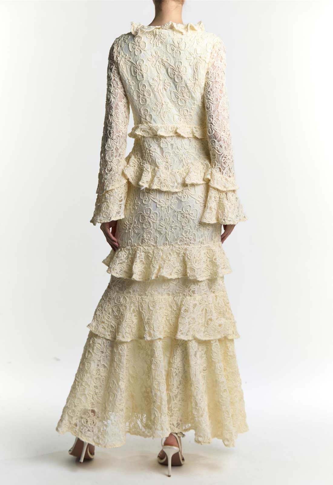 Cream-colored lace dress with ruffled layers on a white background