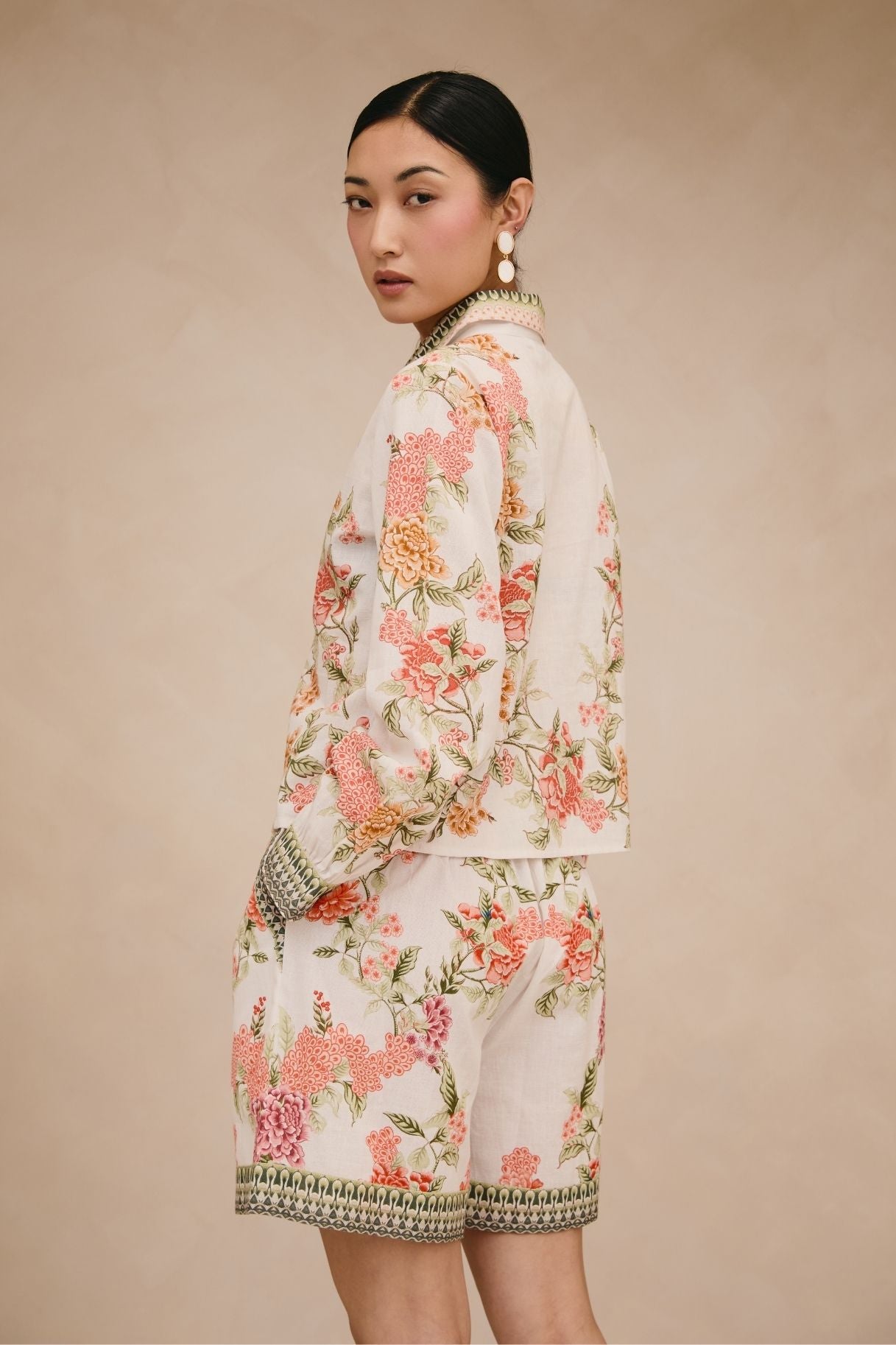 Woman wearing a floral outfit on a beige background