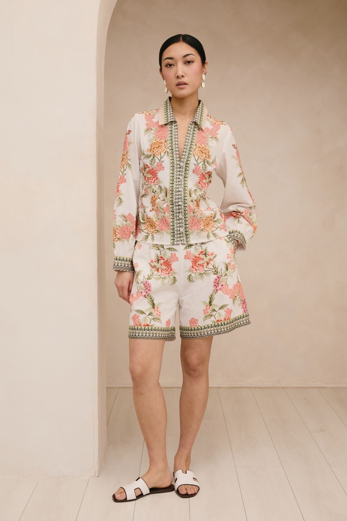 Woman wearing a floral outfit with a neutral background