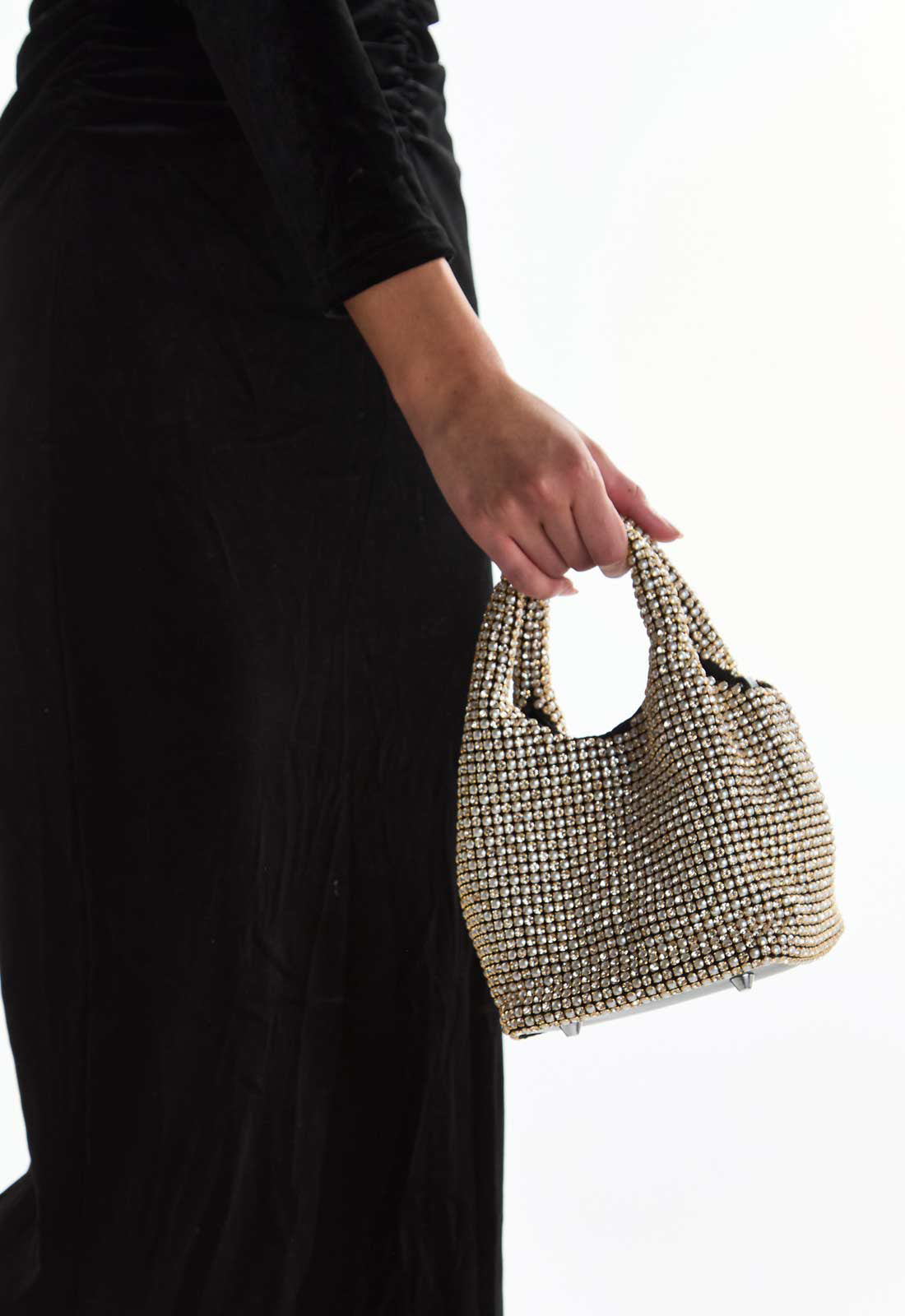 Person holding a textured handbag against a white background