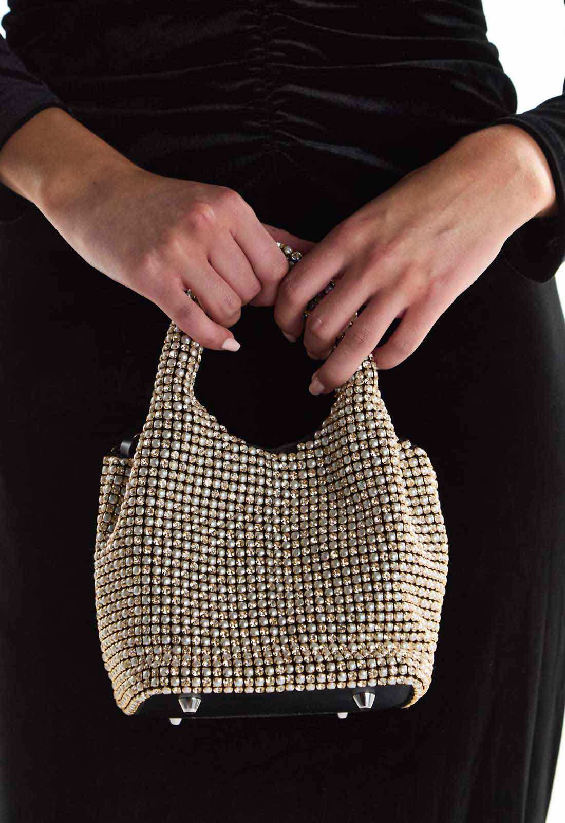Person holding a beaded handbag with a plain background