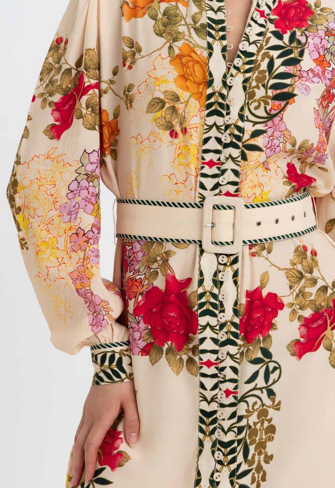 Floral and abstract patterned garment with a hand holding it against a white background