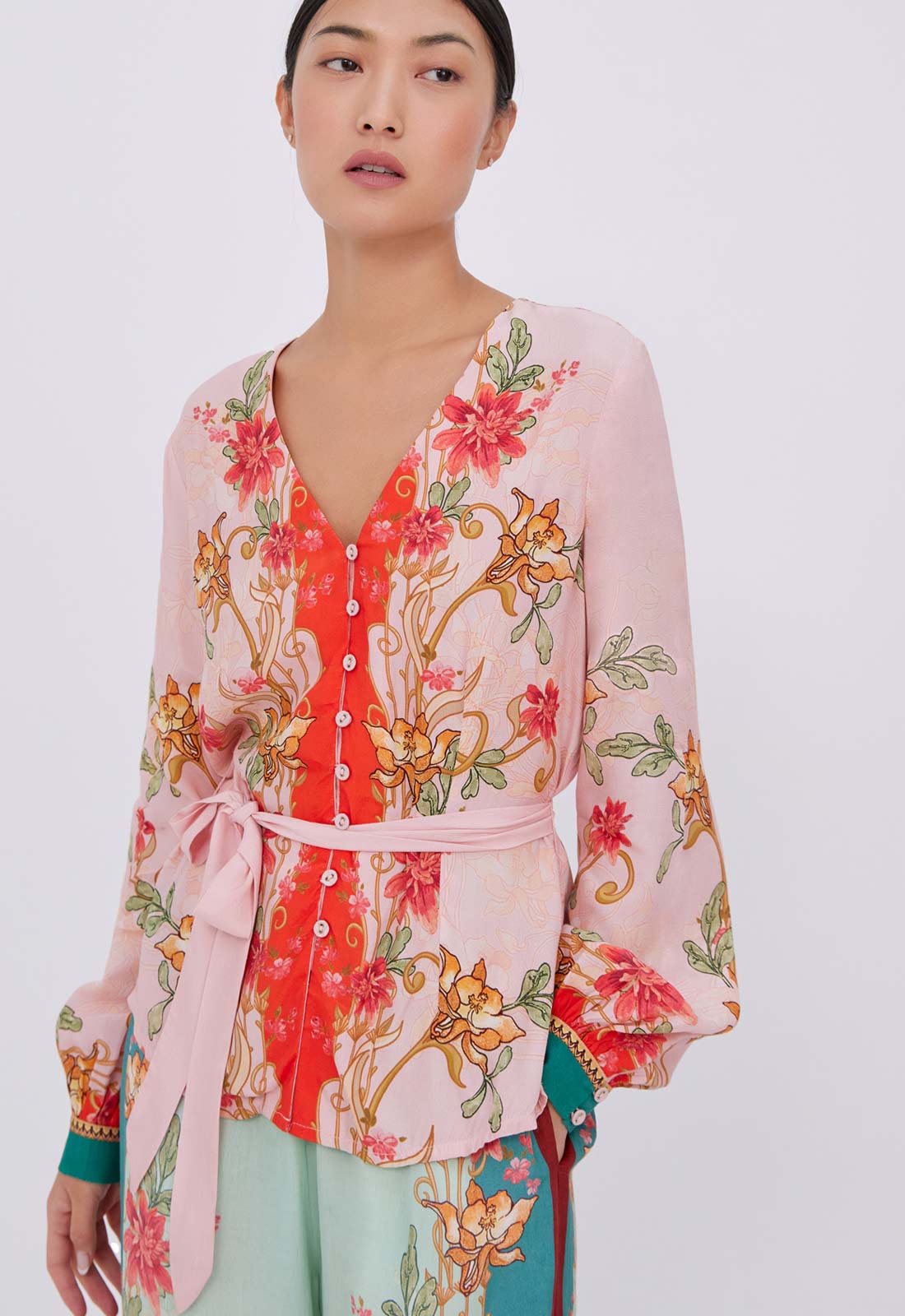 Woman wearing a floral blouse with a white background