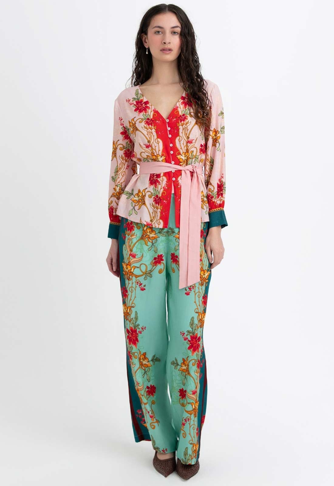 Woman wearing a colorful floral outfit on a white background