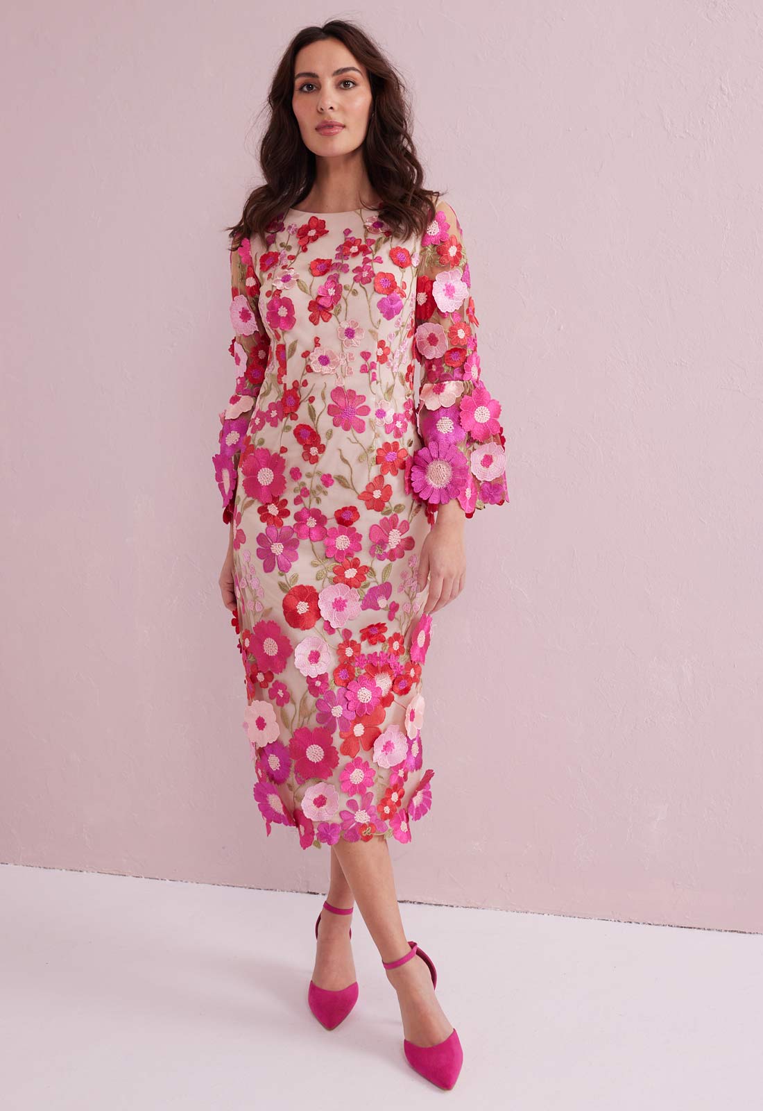 Woman wearing a floral dress against a pink background