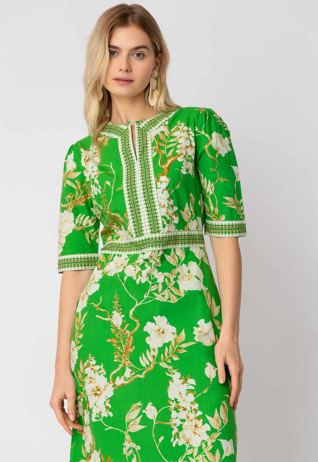 Woman wearing a green floral dress on a white background