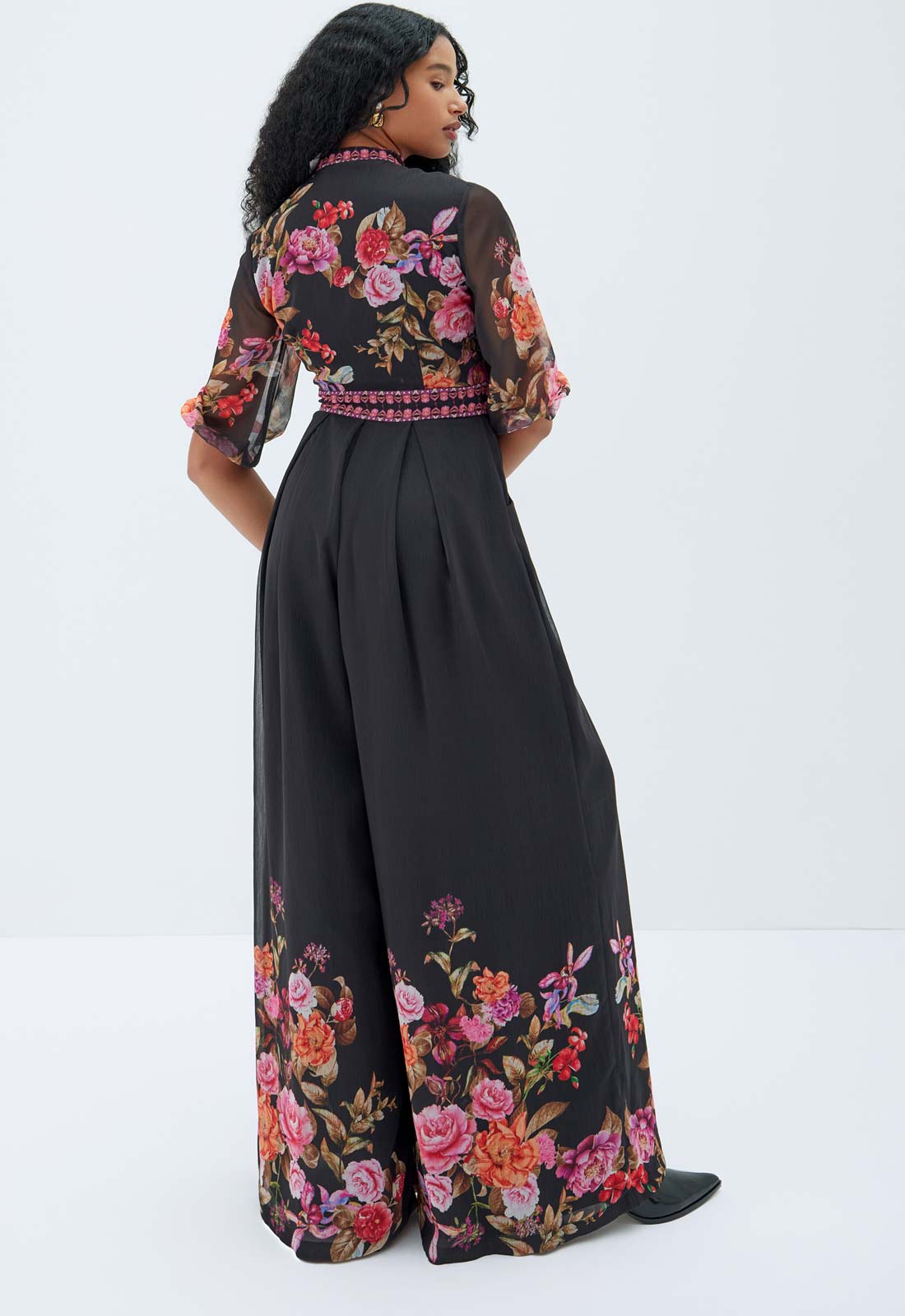 Woman wearing a black outfit with floral patterns on a white background