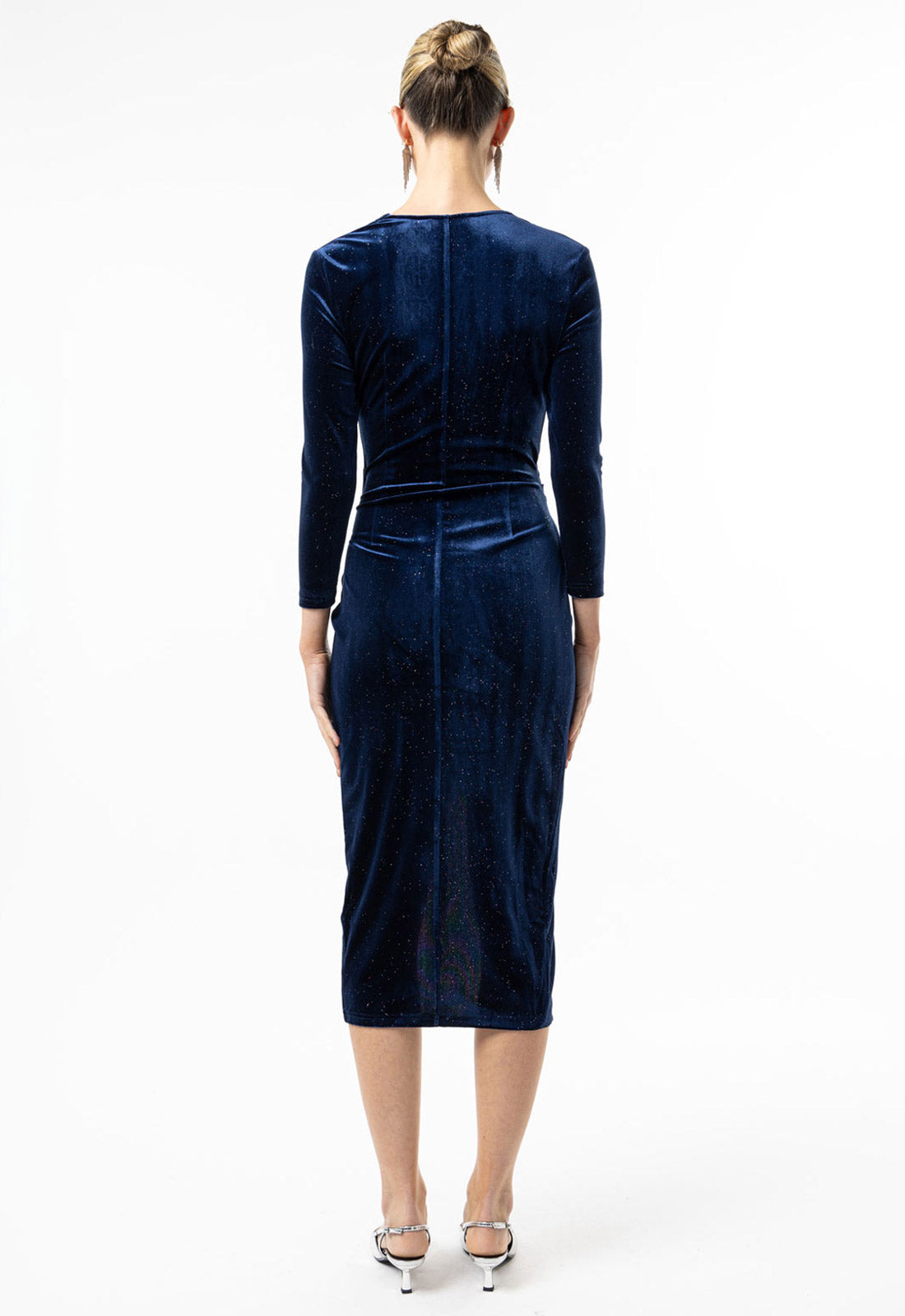 Woman wearing a navy velvet dress on a white background