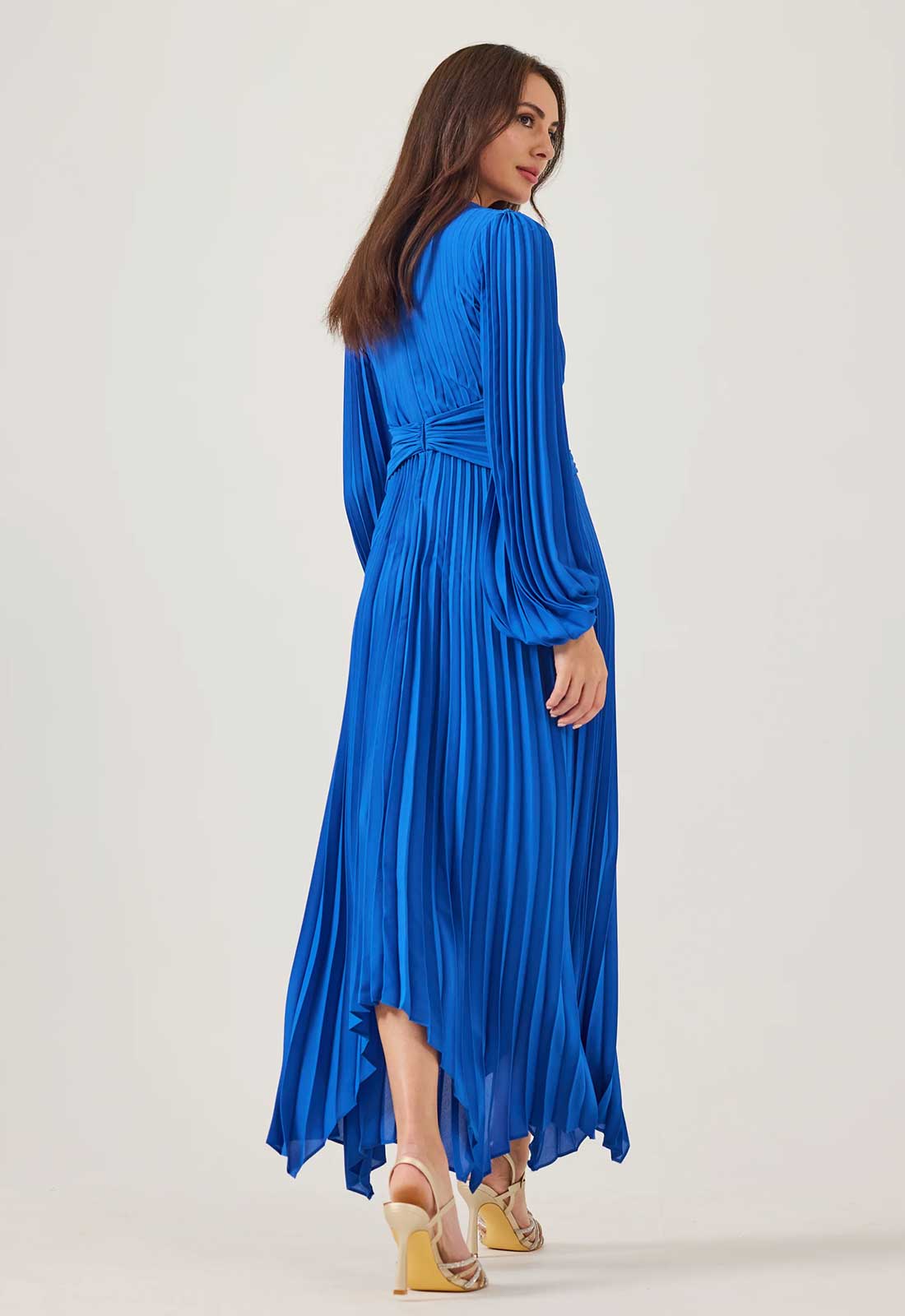Woman wearing a blue pleated dress on a white background