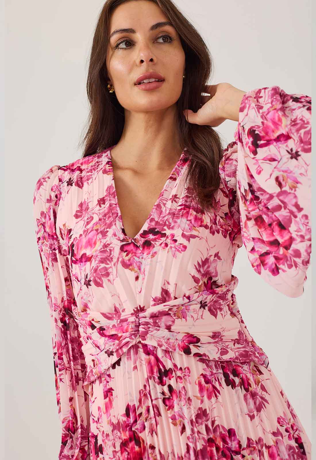 Woman wearing a pink floral dress against a white background