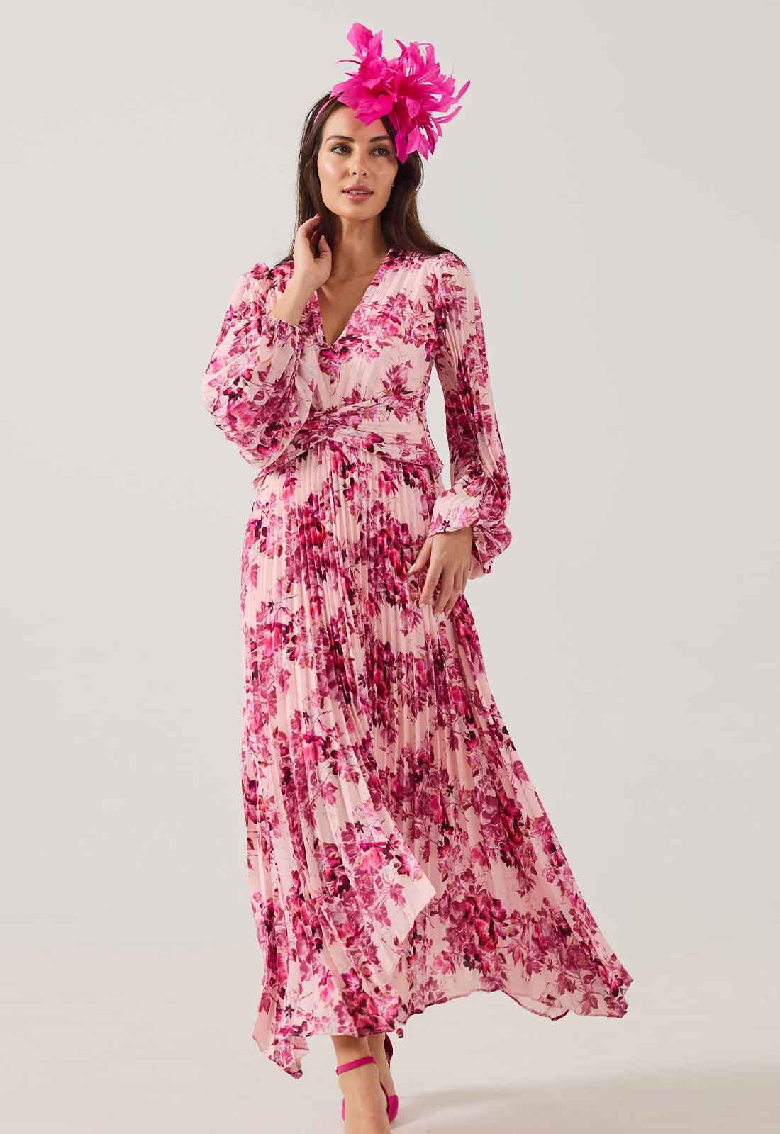 Woman wearing a pink floral dress with a matching headpiece on a white background