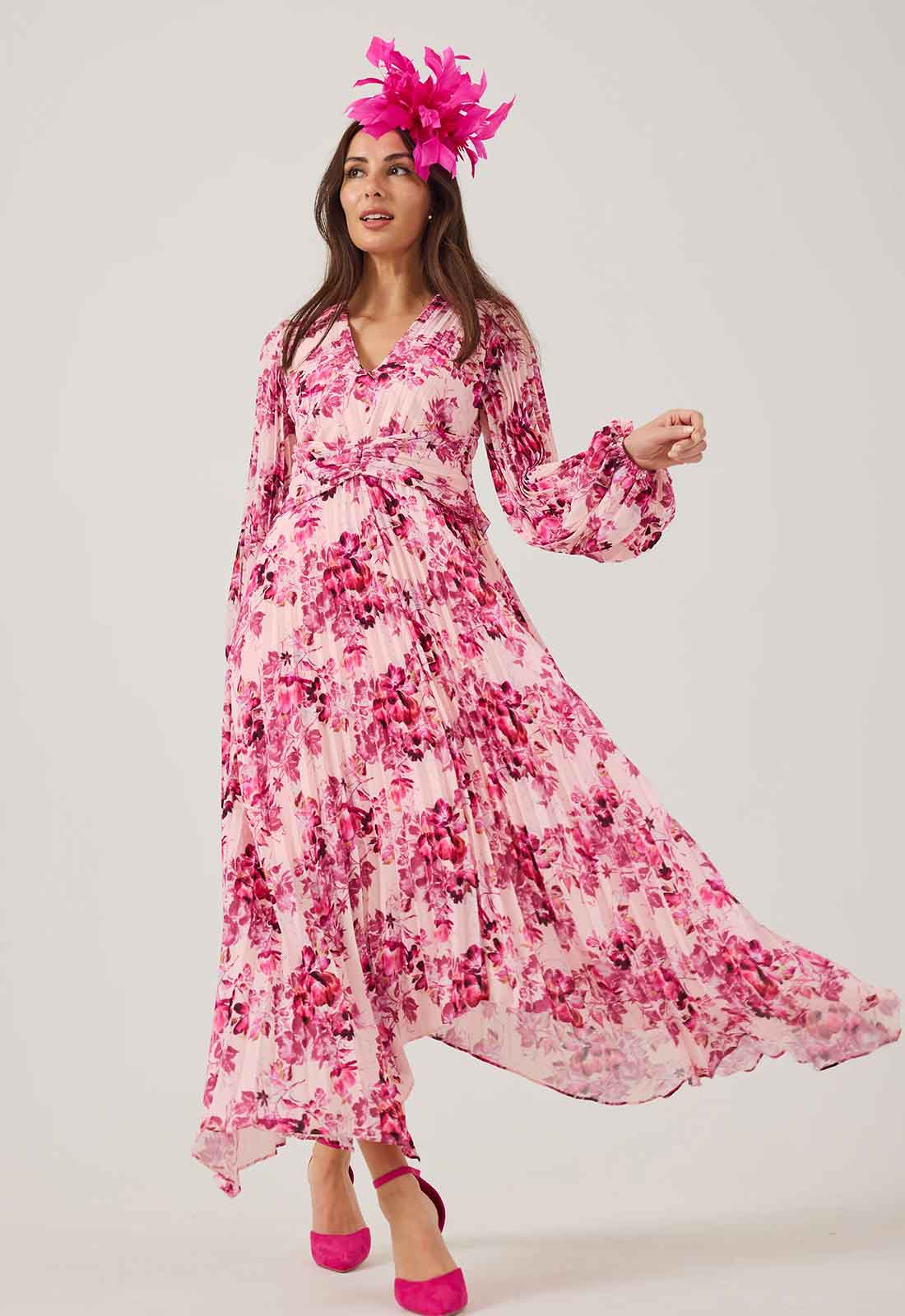 Woman wearing a pink floral dress with a matching headpiece on a white background