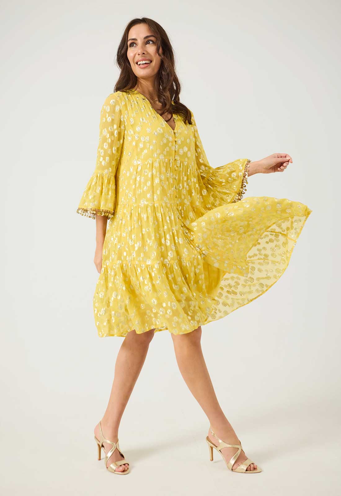 Woman wearing a yellow dress with a white background