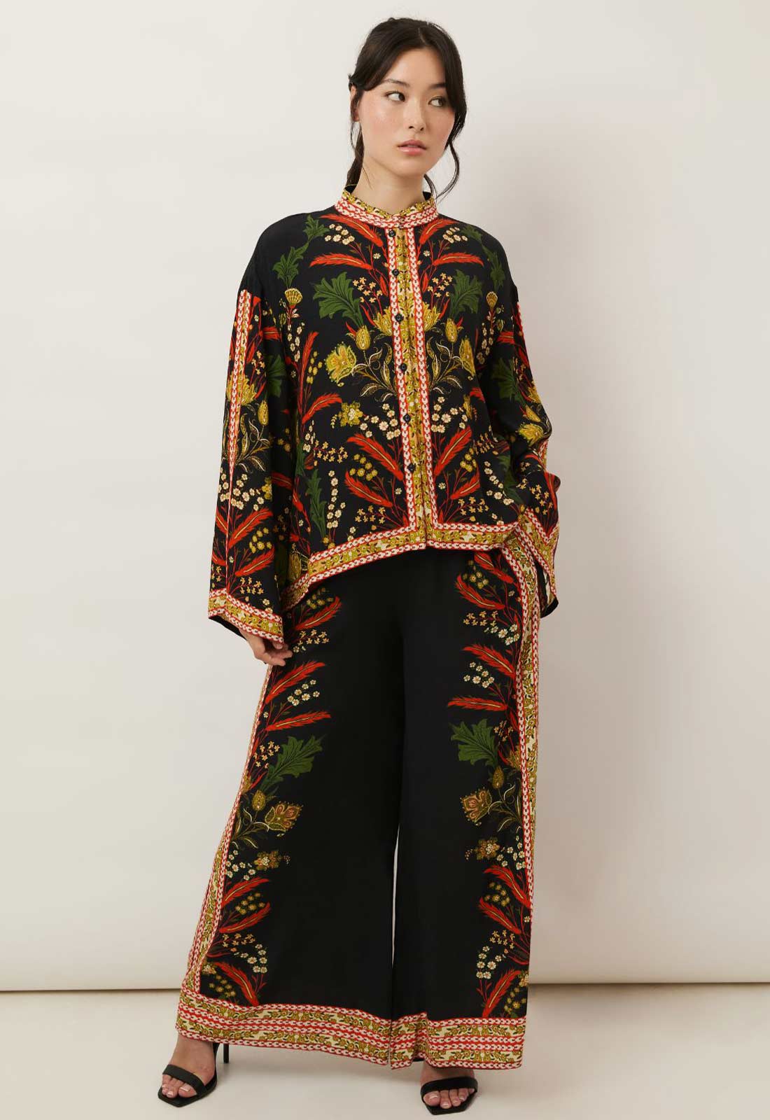 Woman wearing a traditional embroidered outfit with a white background