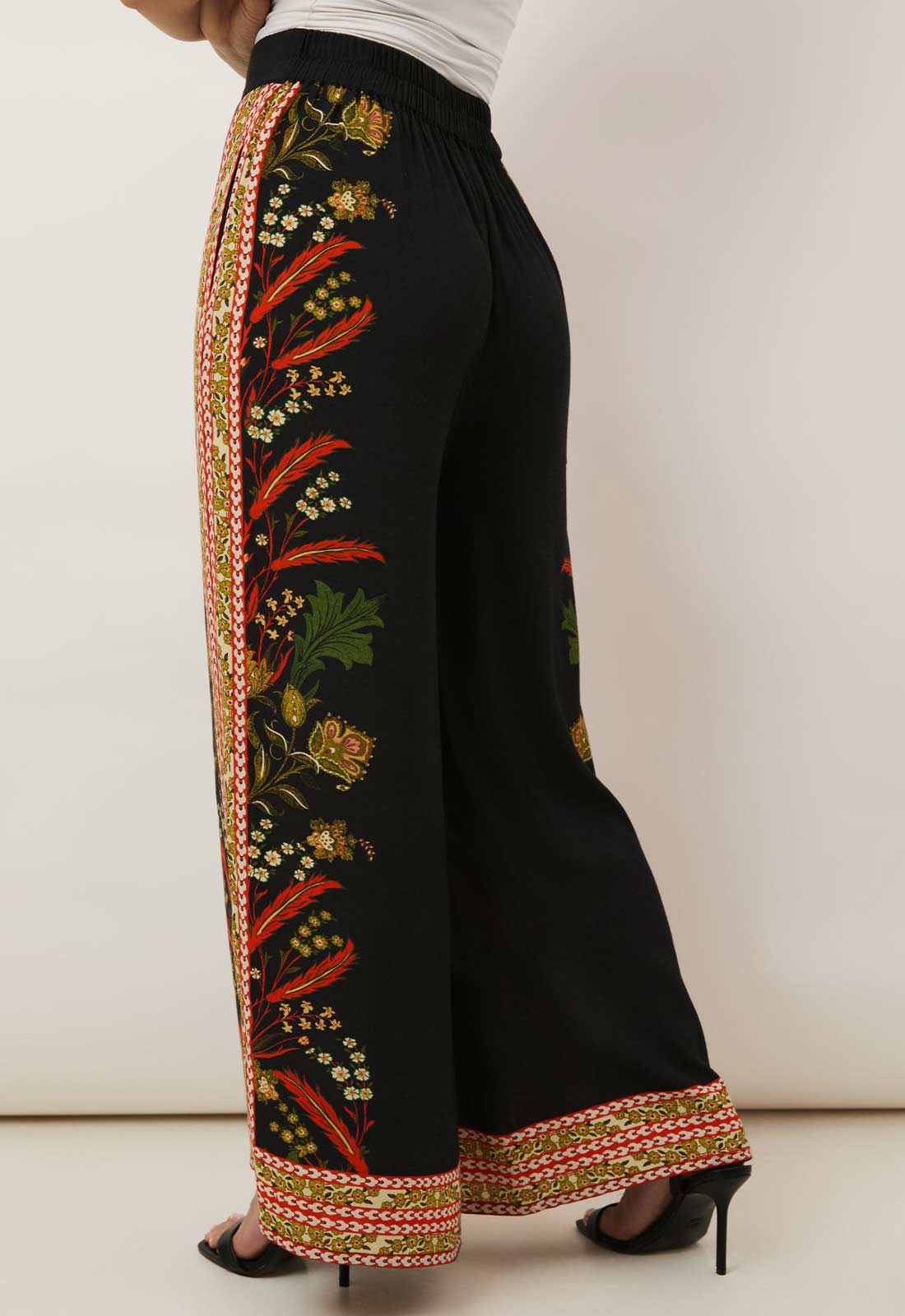 Black pants with colorful embroidery on a white background