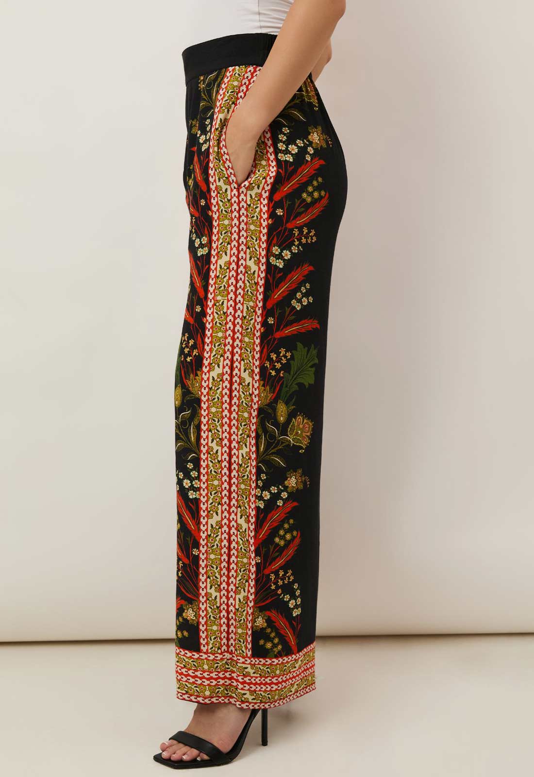 Black pants with colorful floral pattern on a white background