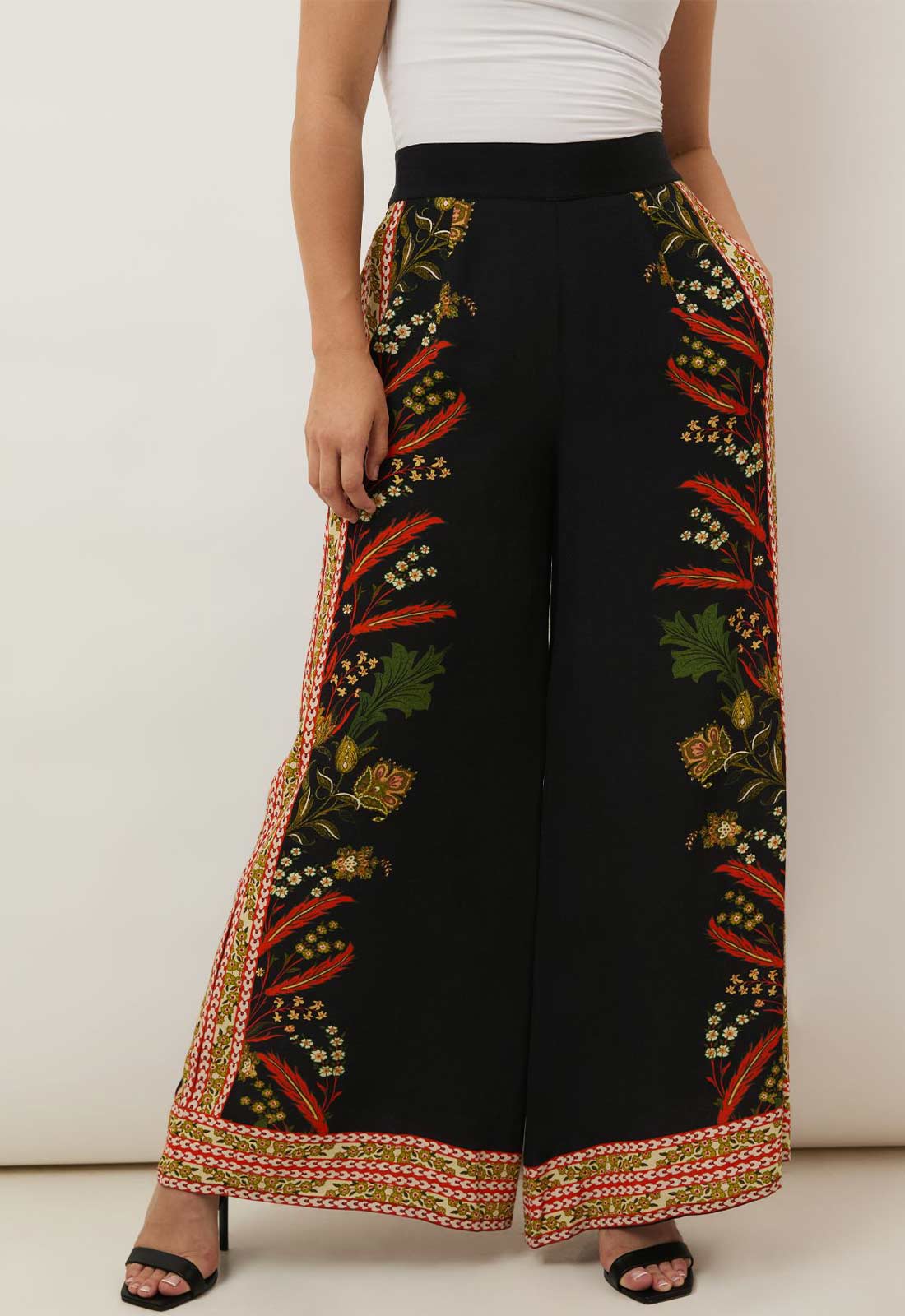 Black pants with colorful embroidery on a white background