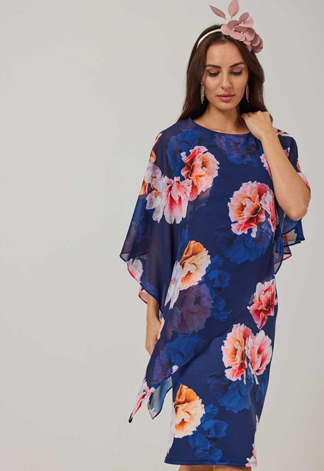 Woman wearing a blue floral dress with a plain background